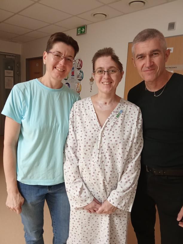 Trojice lidí při společné fotografii v pokoji