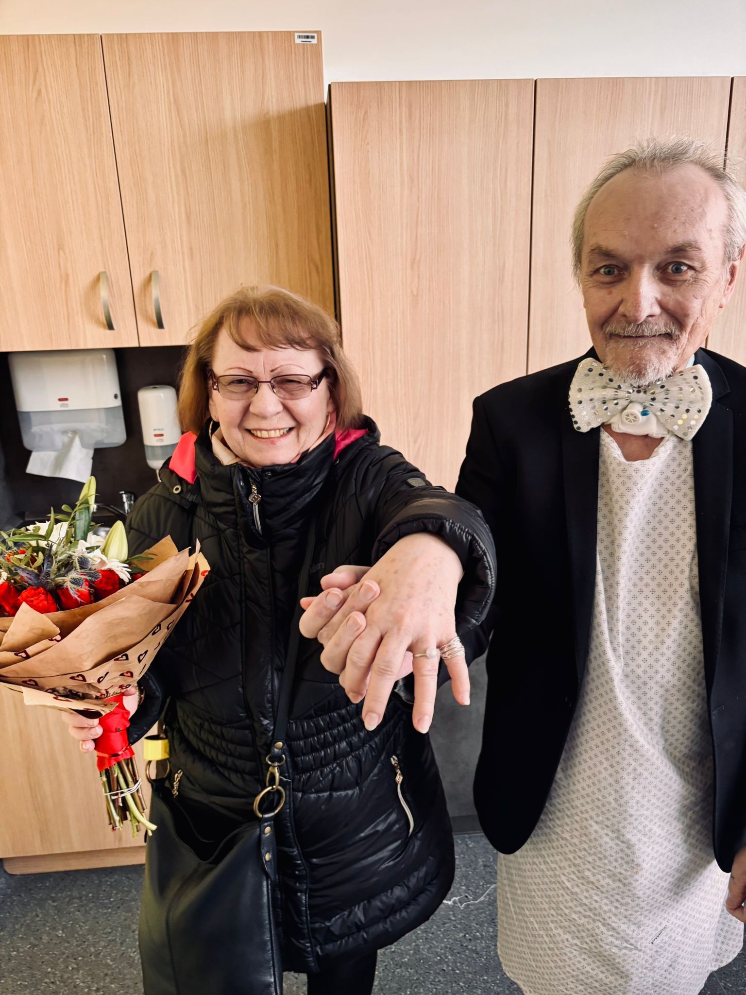 Žena s kyticí a muž stojí vedle sebe.