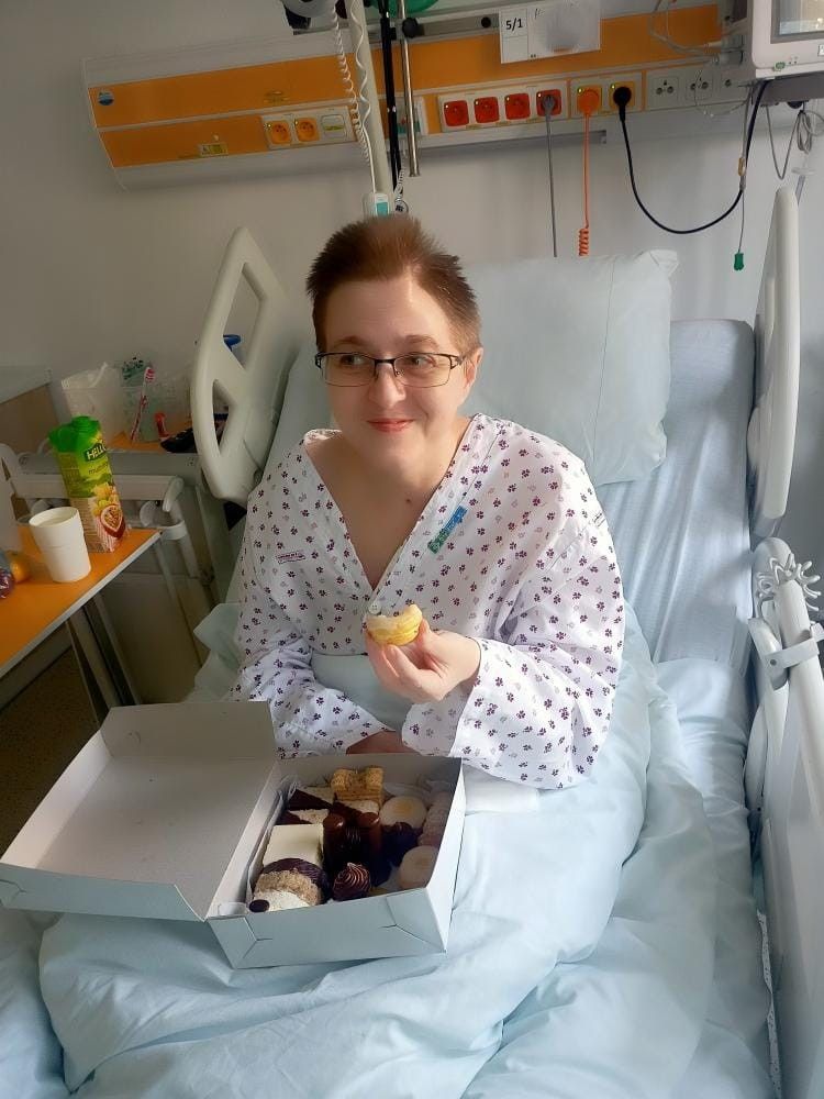 Pacientka sedí na lůžku s občerstvením