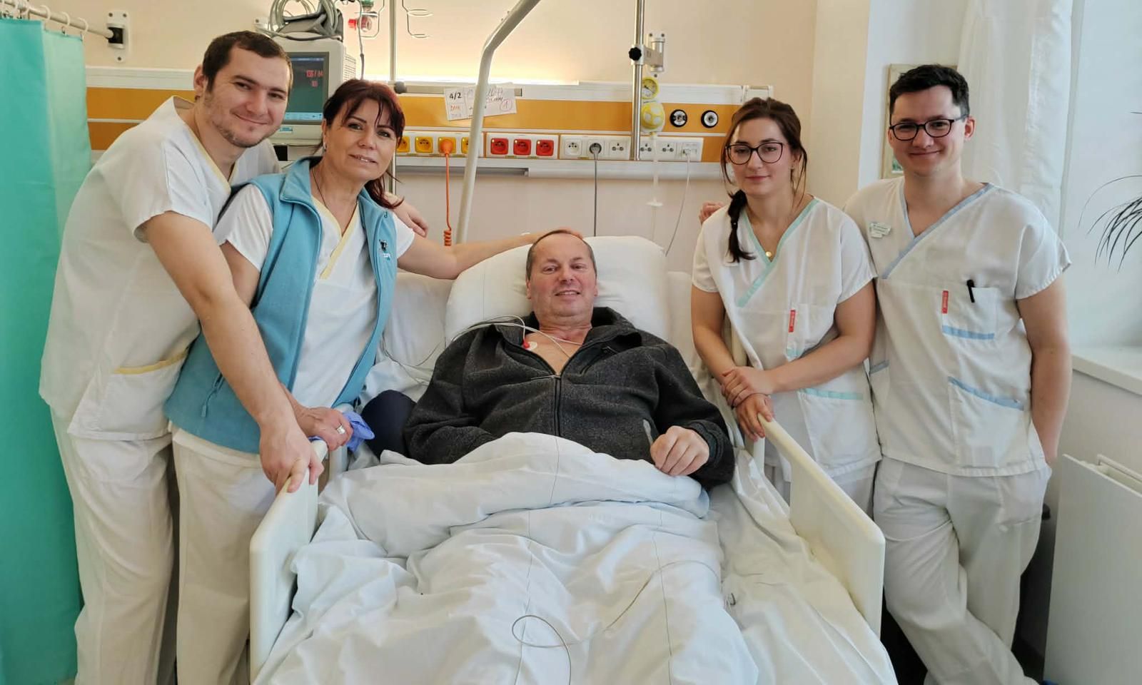 Pacient na lůžku se členy týmu