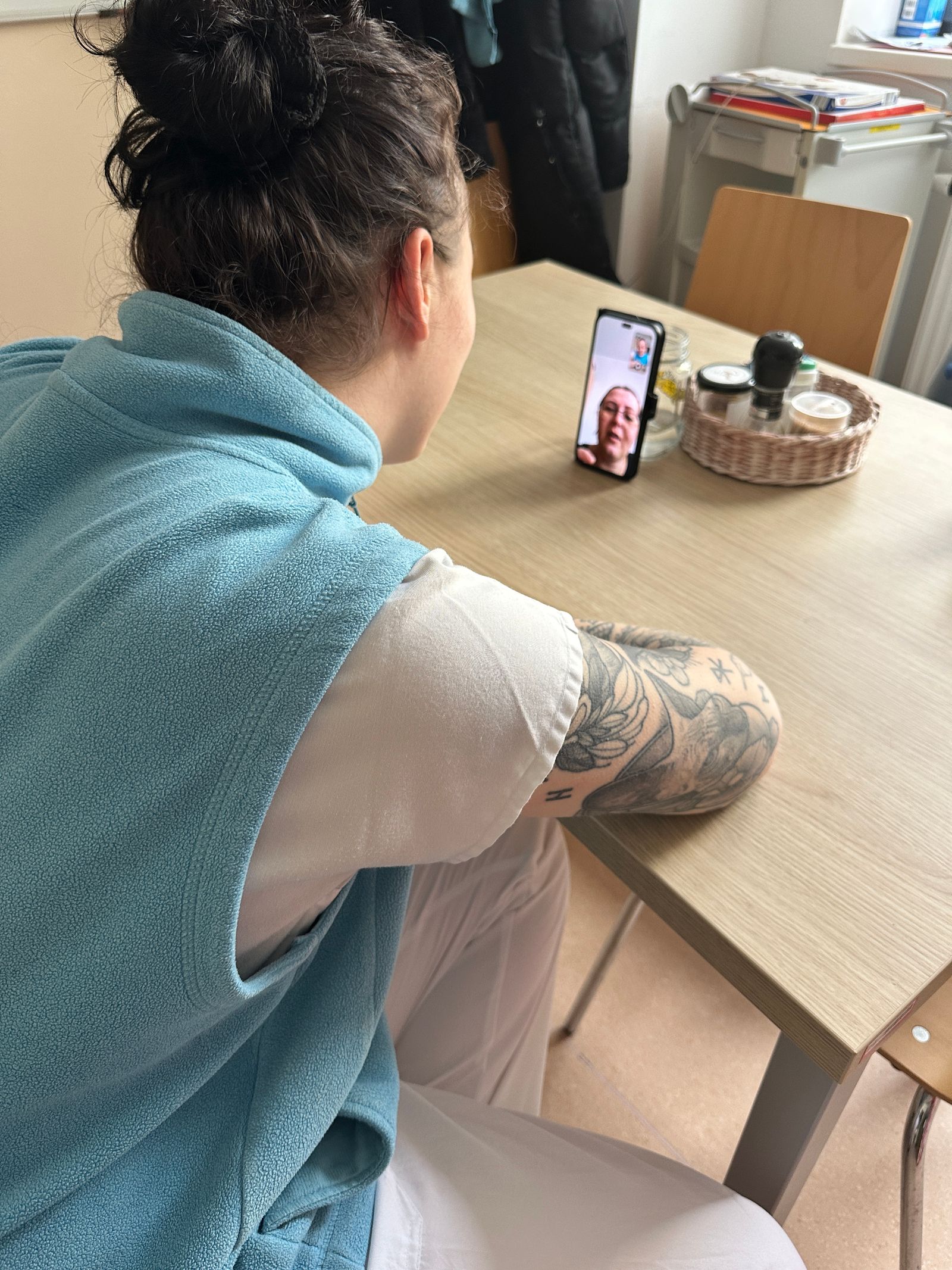Žena u stolu s telefonem při videohovoru