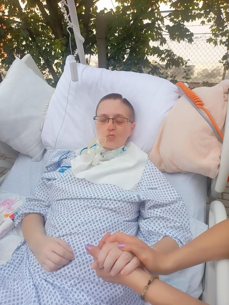 Pacientka na lůžku venku pod stromy